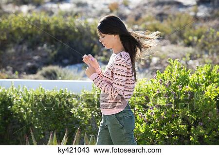 Woman holding a flower in vegetation View Large Photo Image Stock Image - Woman holding a flower in vegetation. Fotosearch