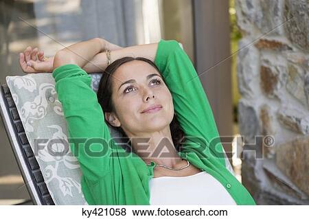 Woman relaxing on a lounge chair View Large Photo Image Stock Photo - Woman relaxing on a lounge chair. Fotosearch