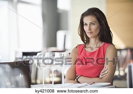 Stock Photo - Woman sitting in a restaurant and thinking. Fotosearch