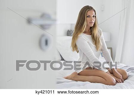 Woman sitting on the bed View Large Photo Image Stock Image - Woman sitting on the bed. Fotosearch