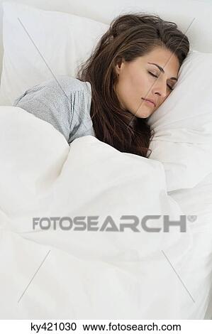 Stock Image - Woman sleeping on the bed. Fotosearch