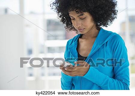 Picture - Close-up of a woman text messaging on a mobile phone. Fotosearch