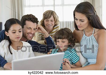 Family looking at a laptop View Large Photo Image Stock Image - Family looking at a laptop. Fotosearch