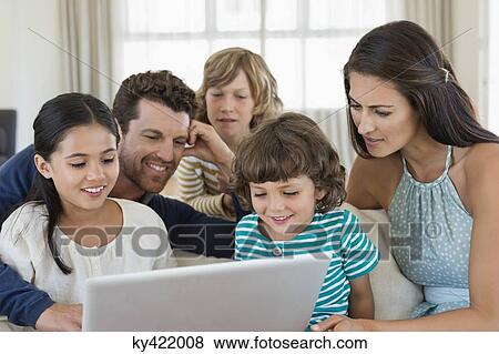 Family looking at a laptop View Large Photo Image Stock Photo - Family looking at a laptop. Fotosearch