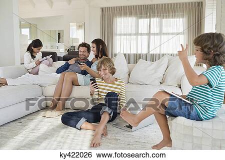 Family using electronics gadget View Large Photo Image Stock Photograph - Family using electronics gadget. Fotosearch