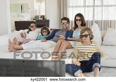 Family watching television at home while wearing 3D glasses View Large Photo Image Stock Image - Family watching television at home while wearing 3D glasses. Fotosearch