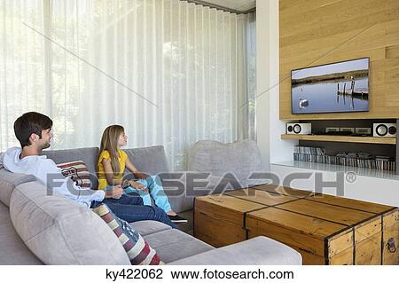 Man and his daughter watching television View Large Photo Image Stock Image - Man and his daughter watching television. Fotosearch