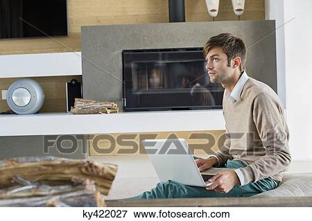 Man using a laptop at home View Large Photo Image Stock Photo - Man using a laptop at home. Fotosearch