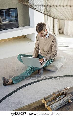 Stock Photo - Man using a laptop at home. Fotosearch
