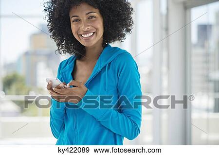 Portrait of a woman text messaging on a mobile phone View Large Photo Image Stock Photo - Portrait of a woman text messaging on a mobile phone. Fotosearch