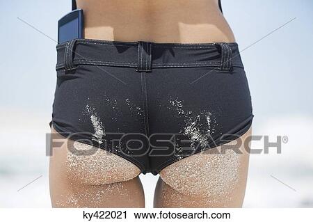 Rear view of a woman standing on the beach View Large Photo Image Stock Image - Rear view of a woman standing on the beach. Fotosearch