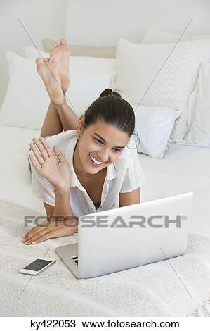 Woman having online video chat on a laptop View Large Photo Image Stock Image - Woman having online video chat on a laptop. Fotosearch