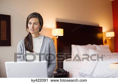 Woman using a laptop in a hotel room View Large Photo Image Stock Image - Woman using a laptop in a hotel room. Fotosearch