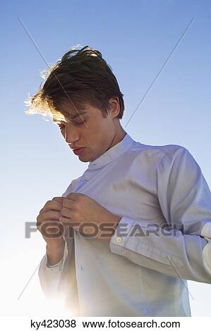 Man buttoning his shirt View Large Photo Image Stock Photo - Man buttoning his shirt. Fotosearch