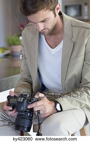Man holding a camera View Large Photo Image Stock Image - Man holding a camera. Fotosearch