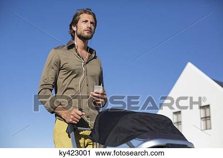 Man standing with a baby stroller View Large Photo Image Stock Image - Man standing with a baby stroller. Fotosearch