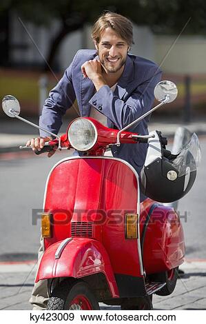 Portrait of a man sitting on a scooter and smiling View Large Photo Image Stock Photo - Portrait of a man sitting on a scooter and smiling. Fotosearch