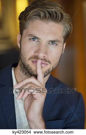 Portrait of a man with his finger on lips View Large Photo Image Picture - Portrait of a man with his finger on lips. Fotosearch
