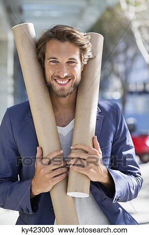 Portrait of an architect holding paper rolls and smiling View Large Photo Image Stock Image - Portrait of an architect holding paper rolls and smiling. Fotosearch