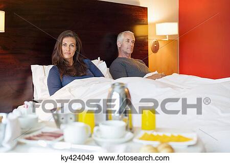Breakfast on table in front of a couple in a hotel room View Large Photo Image Stock Photo - Breakfast on table in front of a couple in a hotel room. Fotosearch