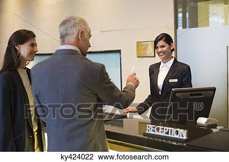 Business couple getting key card at the hotel reception counter View Large Photo Image Stock Image - Business couple getting key card at the hotel reception counter. Fotosearch