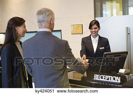 Business couple paying with a credit card at the hotel reception counter View Large Photo Image Stock Image - Business couple paying with a credit card at the hotel reception counter. Fotosearch