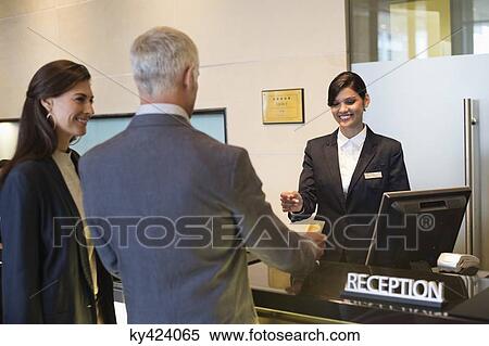 Business couple paying with a credit card at the hotel reception counter View Large Photo Image Stock Photography - Business couple paying with a credit card at the hotel reception counter. Fotosearch
