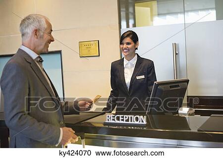 Businessman paying with a credit card at the hotel reception counter View Large Photo Image Stock Image - Businessman paying with a credit card at the hotel reception counter. Fotosearch