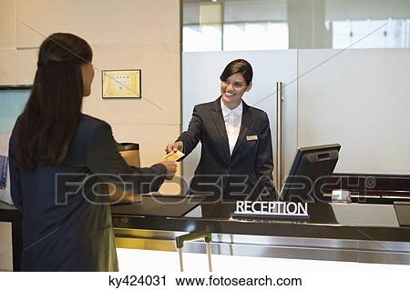 Businesswoman paying with a credit card at the hotel reception counter View Large Photo Image Stock Image - Businesswoman paying with a credit card at the hotel reception counter. Fotosearch