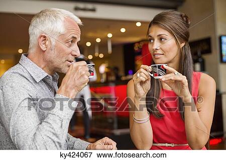 Couple enjoying cup of tea in a restaurant View Large Photo Image Stock Photo - Couple enjoying cup of tea in a restaurant. Fotosearch