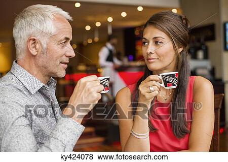 Couple enjoying cup of tea in a restaurant View Large Photo Image Stock Photo - Couple enjoying cup of tea in a restaurant. Fotosearch