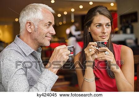Couple enjoying cup of tea in a restaurant View Large Photo Image Stock Photography - Couple enjoying cup of tea in a restaurant. Fotosearch