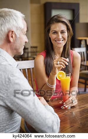 Couple enjoying drink in a restaurant View Large Photo Image Picture - Couple enjoying drink in a restaurant. Fotosearch