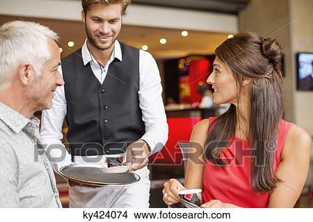 Picture - Waiter serving tea to a couple in a restaurant. Fotosearch