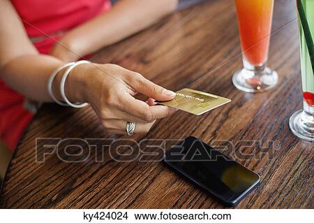 Woman paying with a credit card on a table in a restaurant View Large Photo Image Picture - Woman paying with a credit card on a table in a restaurant. Fotosearch