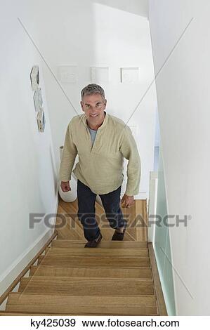 Man moving up on a staircase View Large Photo Image Stock Photo - Man moving up on a staircase. Fotosearch