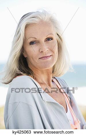 Stock Image - Portrait of a woman smiling on the beach. Fotosearch