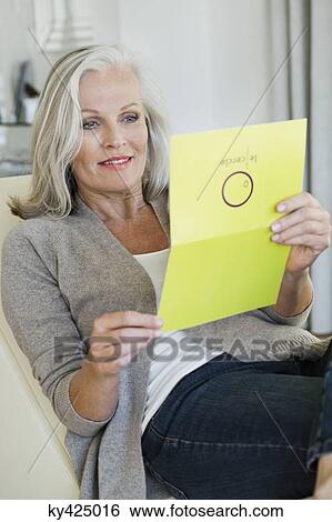 Senior woman reading a greeting card View Large Photo Image Stock Photograph - Senior woman reading a greeting card. Fotosearch
