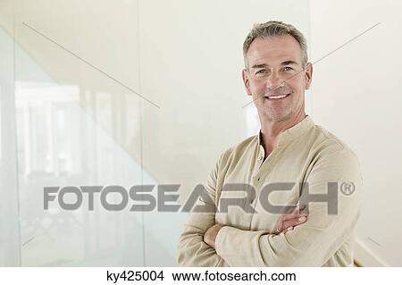 Smiling man standing with his arms crossed View Large Photo Image Picture - Smiling man standing with his arms crossed. Fotosearch