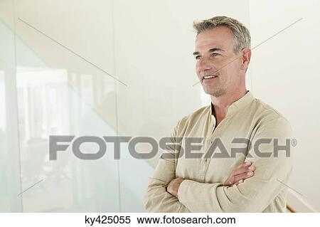 Stock Photography - Smiling man standing with his arms crossed. Fotosearch