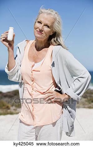 Woman enjoying probiotic drink on the beach View Large Photo Image Stock Photography - Woman enjoying probiotic drink on the beach. Fotosearch