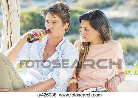 Stock Photo - Couple enjoying beer outdoors on a vacation. Fotosearch