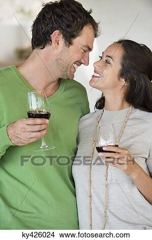 Couple holding wine glasses and smiling View Large Photo Image Picture - Couple holding wine glasses and smiling. Fotosearch
