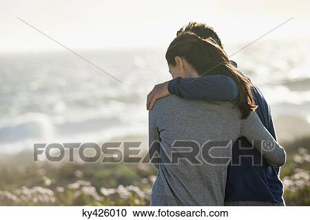 Stock Image - Couple standing on the beach. Fotosearch