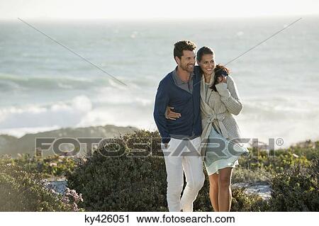 Stock Image - Couple walking on the beach. Fotosearch