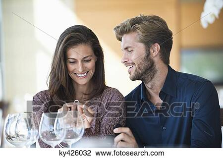 Man giving engagement ring to his girlfriend in a restaurant View Large Photo Image Stock Image - Man giving engagement ring to his girlfriend in a restaurant. Fotosearch
