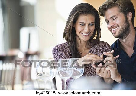 Stock Photography - Man giving engagement ring to his girlfriend in a restaurant. Fotosearch