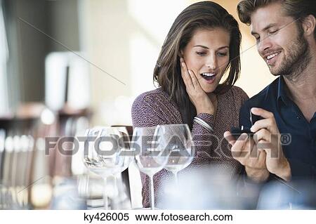 Stock Photography - Man with engagement ring proposing his girlfriend in a restaurant. Fotosearch