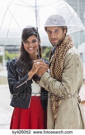 Portrait of a smiling couple under an umbrella View Large Photo Image Stock Image - Portrait of a smiling couple under an umbrella. Fotosearch