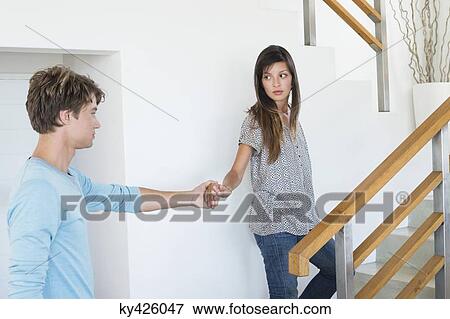 Romantic couple holding hands on a staircase View Large Photo Image Stock Photo - Romantic couple holding hands on a staircase. Fotosearch